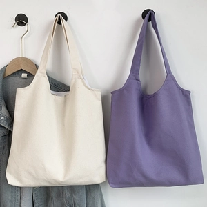 Detail showing high-quality canvas fabric texture on cream and purple tote bags