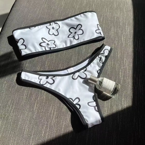 Chic strapless white bikini set with black floral patterns and high-cut swim bottoms