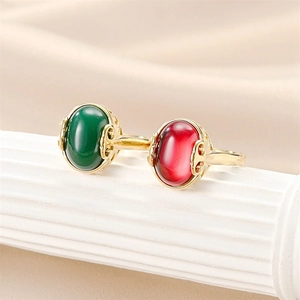 Detail of vintage gold rings with green chalcedony and red ruby set on a white pillar