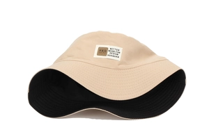 Detail of reversible beige and black sun hat with stitched brim and logo woven label
