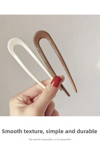 Close-up of cream white and coffee brown U-shaped hair pins with glossy finish