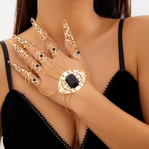 Dettaglio di un bracciale gotico dorato con cinque anelli e una pietra preziosa nera quadrata