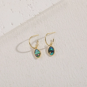 Detail of gold drop earrings featuring abalone shell inlay and small zircon accents