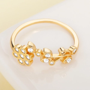Macro shot of gold floral ring with leaf motifs and sparkling white zircon stones