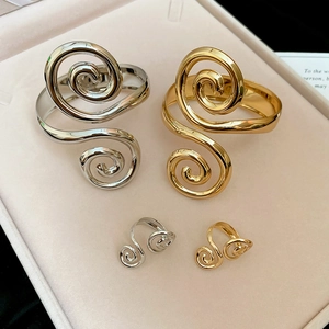 Close-up of gold and silver spiral metal bracelets and rings on a jewelry tray