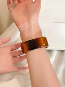 Close-up of wide amber acrylic cuff bracelet with vintage geometric irregular texture