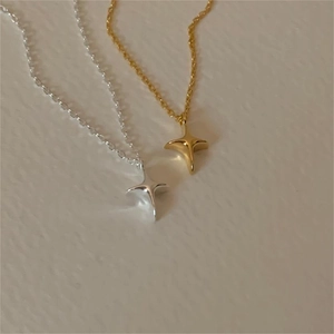 Detailed close-up of gold and silver four-pointed star necklaces on leather texture