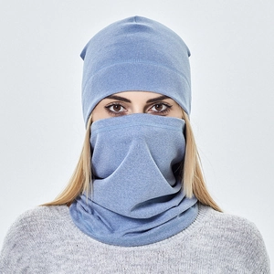 Close-up of light blue knitted beanie hat and matching neck warmer set on a model
