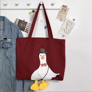 Detail of dark red canvas tote with cartoon duck print and 3D plush feet decoration