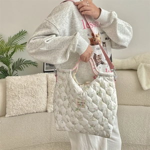 Detailed shot of quilted floral bunny tote with pink strap in cozy home setting
