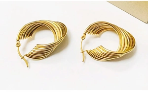 Macro detail of high-polished 18K gold-plated stainless steel twisted hoop earrings