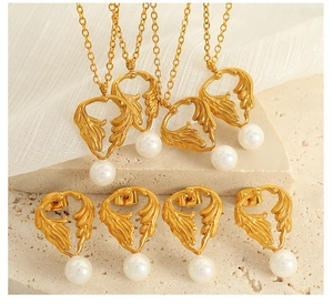Detailed view of gold leaf jewelry set with white pearls on a natural stone base
