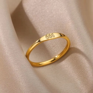 Detailed view of gold stainless steel ring with 666 engraving on champagne silk