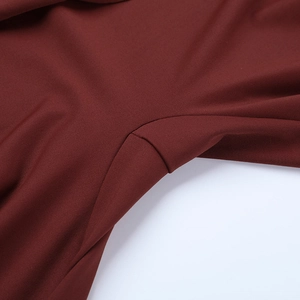 Close-up of wine red knit fabric seams and fine texture on the slim fit jumpsuit