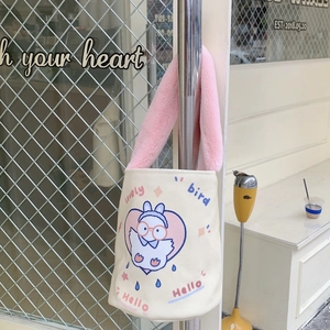 Dettaglio della stampa uccellino e manico in peluche rosa su borsa a secchiello