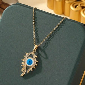 Macro shot of evil eye pendant with blue enamel and pavé crystals on gold necklace