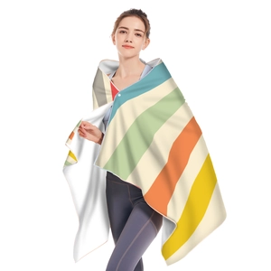 Detail showing colorful striped microfiber hooded beach towel worn as a wearable poncho