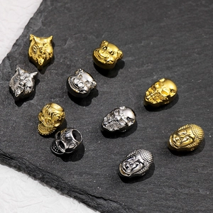 Detail of assorted gold and silver wolf, skull, and Buddha stainless steel beads