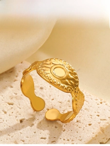 Detail of vintage oval golden stainless steel ring with hammered texture and beaded edges