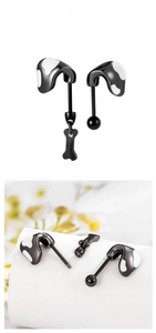 Detail of black titanium steel ear studs with bone pendant and screw ball backs