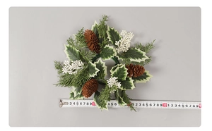 Detail of Christmas candle ring with pine cones and white berries next to a measuring tape