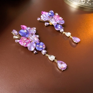 Elegant gold drop earrings with purple floral gradient, crystals, and diamonds on leather