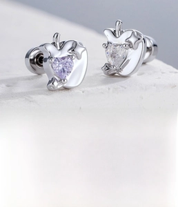Detail of silver apple stud earring with purple heart zircon and starburst design