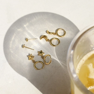Luxurious gold stainless steel earring set featuring star and moon charms with artistic shadows