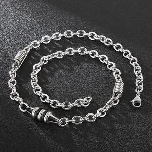 Macro detail of silver titanium steel chain necklace with bullet pendant on black background