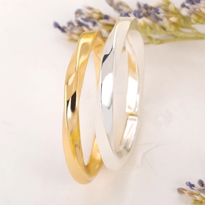 Close-up of gold matte and silver polished Mobius rings with twisted interlocking design
