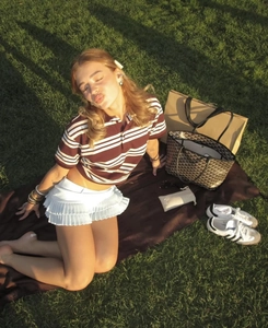 Scena di picnic all'aperto con polo a righe e gonna a pieghe bianca coordinata