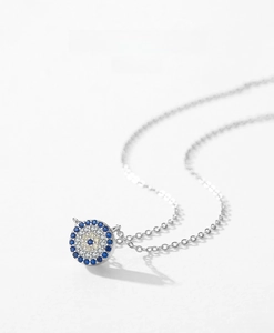 Detailed macro shot of S925 silver Evil Eye pendant with sparkling blue and white crystals