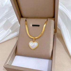 Golden heart necklace with iridescent inlay in a beige jewelry gift box on silk