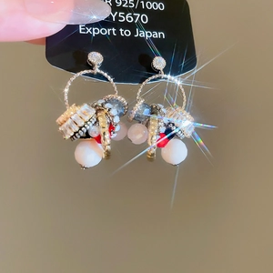 Detail of 925 silver needle earrings with resin beads and cubic zirconia pendants