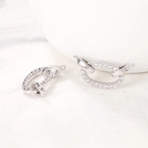 Gros plan sur des connecteurs de boucles d'oreilles argentés avec strass brillants
