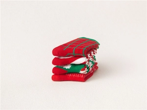 Detailed view of folded Christmas cotton socks featuring Santa Claus and striped patterns