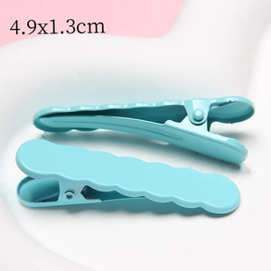 Detail showing two light blue wavy hair clips measuring 4.9x1.3cm on a heart-shaped tray