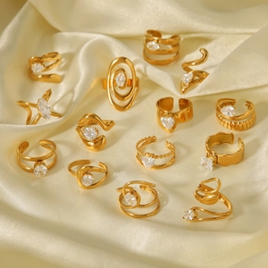 Close-up of 13-piece gold-plated geometric ring set with zircon on champagne silk fabric