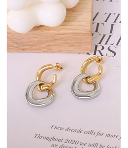 Detailed close-up of interlocking gold and silver geometric hoops with mirror finish