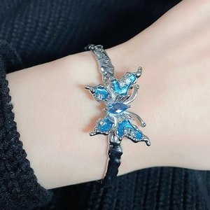 Dettaglio macro del bracciale a farfalla in smalto blu con cristalli sul polso