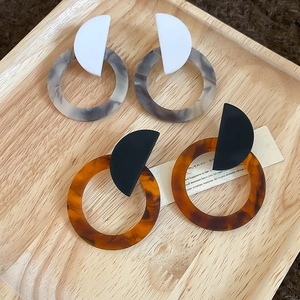 Detail view of geometric resin drop earrings in marble and tortoiseshell patterns