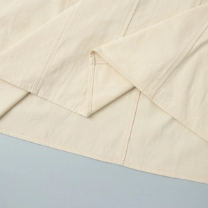Detail view of cotton dress hem showing professional stitching and overlock seams
