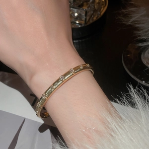 Close-up of 18k gold plated textured bangle with sparkling zircon stones on a model's wrist
