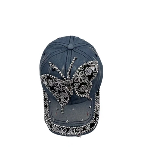 Detailed view of the rhinestone butterfly and floral pattern on the denim baseball cap