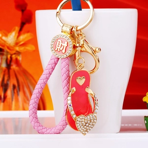 Detail of pink flip-flop keychain with rhinestones and lucky gold coin on cup rim