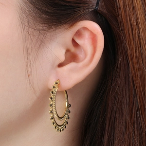 Side view of model wearing vintage gold double hoop earrings with black bead detailing