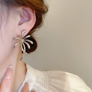 Close-up of a silver floral stud earring with abstract polished lines on a female model