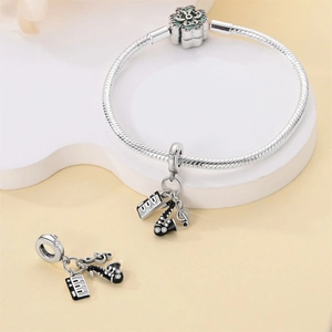 Silver snake chain bracelet with green floral beads and musical instrument pendants