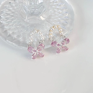 Detailaufnahme der rosa Kristall-Schmetterlingsohrringe mit Perlen und silbernen Akzenten