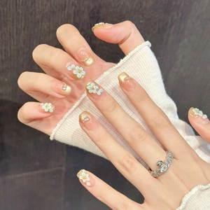 Pink and gold gradient press-on nails with 3D floral accents and micro pearls